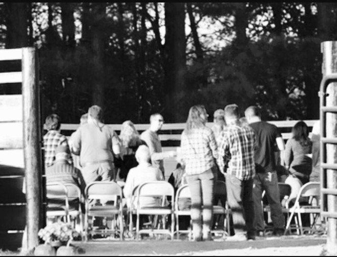 black and white picture of chairs and people in a round pen for an event